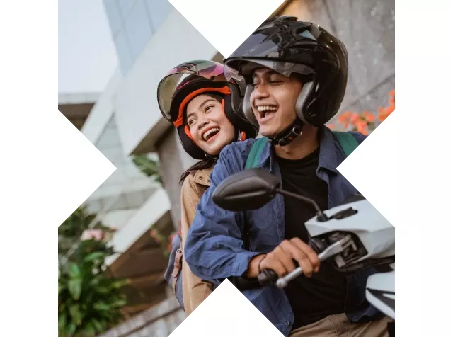 Hombre y mujer sentados en una moto, satisfechos con nuestro producto Pluxee Gasolina.